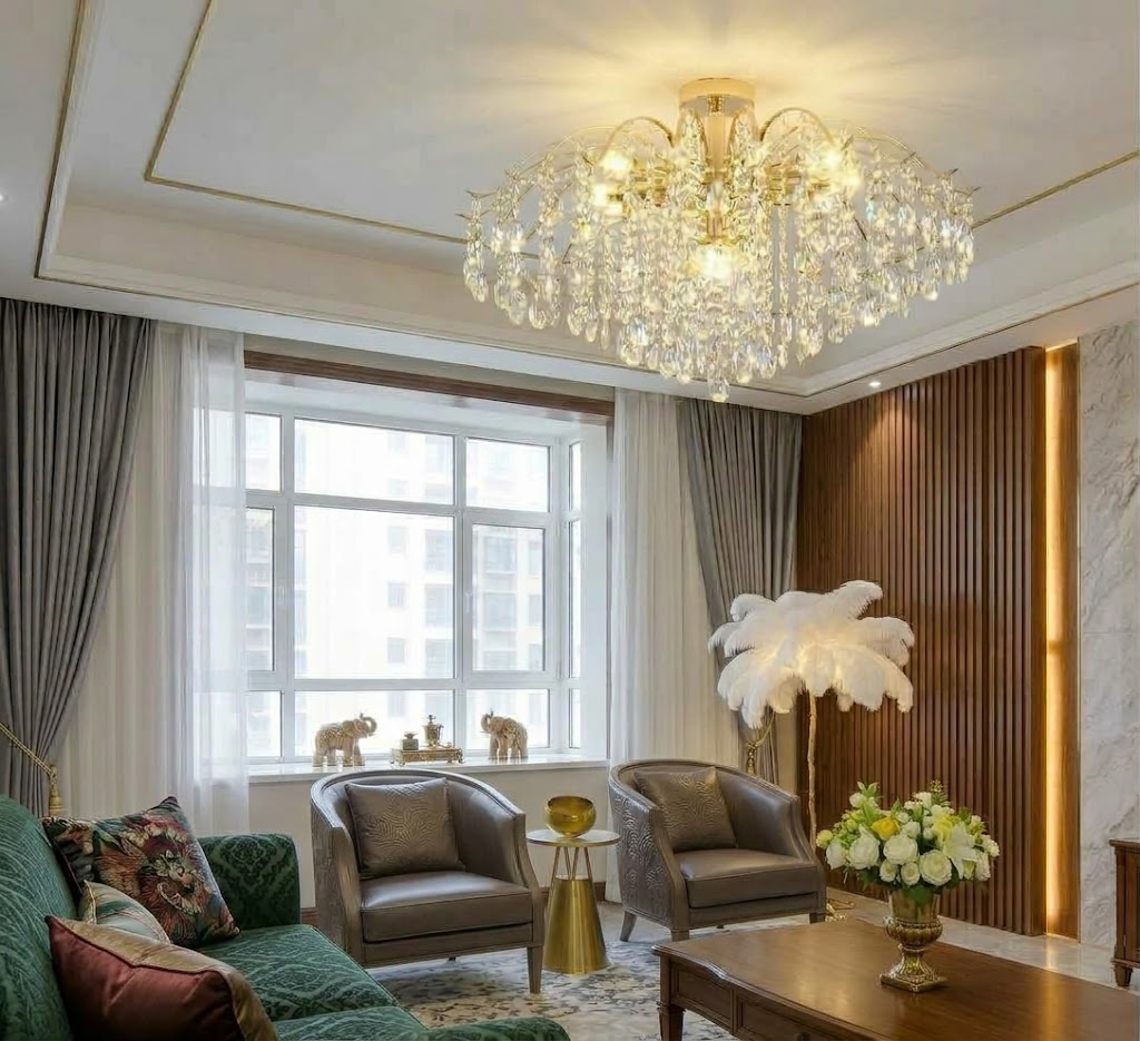 Plafonnier en cristal doré allumé dans un salon avec canapé vert